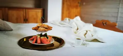 a plate of fruit and a pastry on a bed at Sarni Szlak in Zawoja