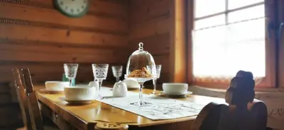 a dining room table with a wine glass on it at Sarni Szlak in Zawoja