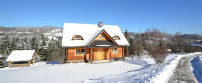 a wooden cabin with a snow covered roof at Sarni Szlak in Zawoja
