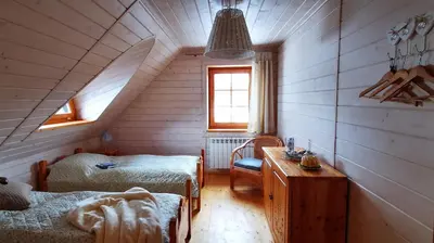 a attic room with two beds and a table at Sarni Szlak in Zawoja