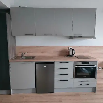 a kitchen with white cabinets and a sink at Sympozjum Loft in Kraków