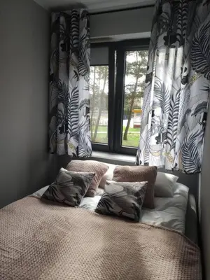 a bed with pillows in a bedroom with a window at Przytulne mieszkanko in Oświęcim
