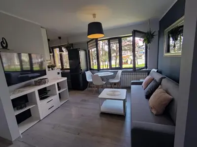 a living room with a couch and a tv and a table at Przytulne mieszkanko in Oświęcim