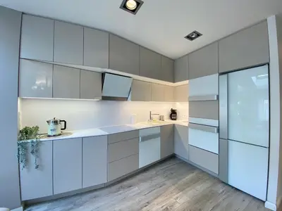 a kitchen with white cabinets and a refrigerator at Garbarska LUX with Air Condition in Kraków