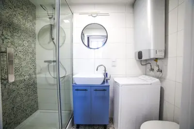 a bathroom with a blue sink and a shower at CracWoW Saint Sebastian Apartments in Kraków