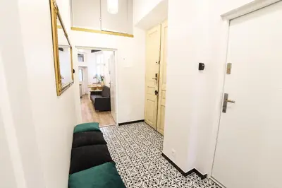a hallway with a green couch in a white room at CracWoW Saint Sebastian Apartments in Kraków