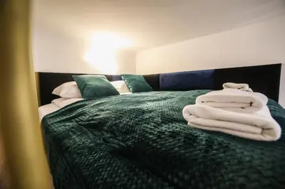 a bedroom with a bed with towels on it at CracWoW Saint Sebastian Apartments in Kraków