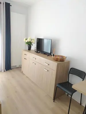 a living room with a tv on top of a dresser at Doskonałe mieszkanie z tarasem blisko centrum Krakowa in Kraków