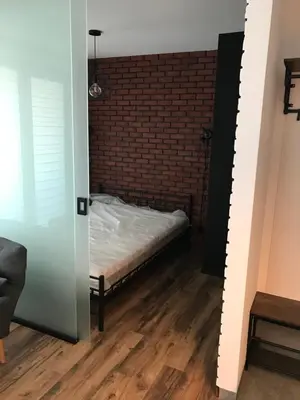 a bedroom with a bed and a brick wall at Pszczelna Loft in Kraków