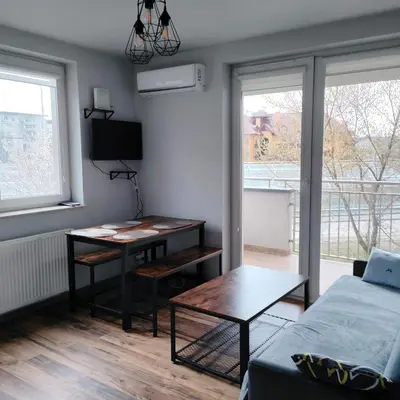 a living room with a table and a bed at Pszczelna Loft in Kraków
