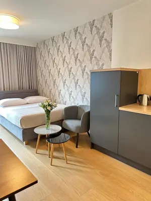 a hotel room with a bed and a table at Native Apartments Barska 69 in Kraków