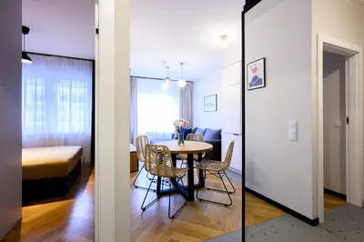 a room with a table and chairs and a bedroom at Native Apartments Barska 69 in Kraków