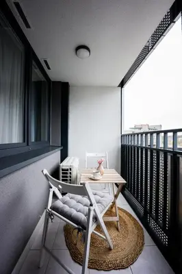 a balcony with a table and a chair on a balcony at Native Apartments Barska 69 in Kraków