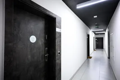 a corridor of an office building with a door at Native Apartments Barska 69 in Kraków