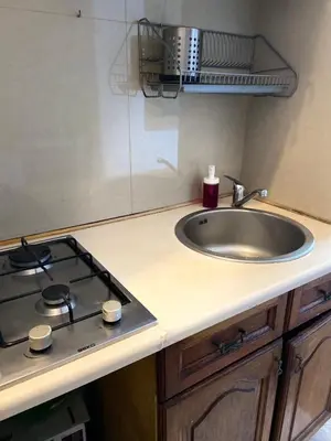 a kitchen counter with a sink and a stove at Historic Apartment in Kraków