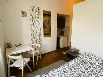 a bedroom with a bed and a desk and a table at Historic Apartment in Kraków