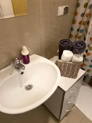 a bathroom with a sink and a basket of towels at Historic Apartment in Kraków