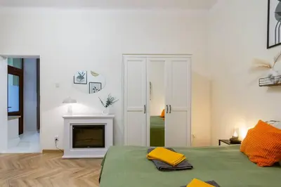 a white room with a bed and a fireplace at Paulinska20-Kaziermierz-2 Rooms in Kraków