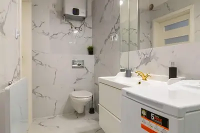 a white bathroom with a toilet and a sink at Paulinska20-Kaziermierz-2 Rooms in Kraków