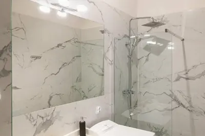 a bathroom with a shower and a sink and a mirror at Paulinska20-Kaziermierz-2 Rooms in Kraków