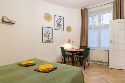 a bedroom with a bed and a table and chairs at Paulinska20-Kaziermierz-2 Rooms in Kraków