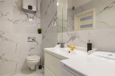 a white bathroom with a sink and a toilet at Paulinska20-Kaziermierz-2 Rooms in Kraków