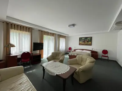 a hotel room with a bed and a living room at Hotel August in Brzesko