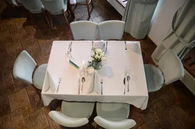 a table with chairs and a white tablecloth and flowers at Hotel August in Brzesko