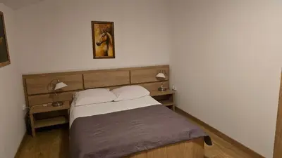 a bedroom with a bed with two lamps on it at Hotel August in Brzesko