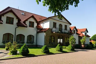 a white house with a red roof at Hotel August in Brzesko
