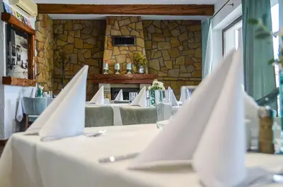 a table with white cloths on it in a restaurant at Hotel August in Brzesko