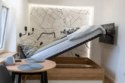 a bed on a wall in a room with a table at mN apartments home - Wieliczka Town in Wieliczka