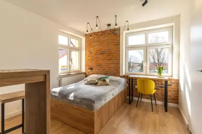 a bedroom with a bed and a brick wall at mN apartments home - Wieliczka Town in Wieliczka