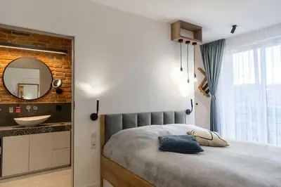 a bedroom with a bed with a mirror and a sink at mN apartments home - Wieliczka Town in Wieliczka