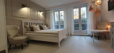 a bedroom with a bed and two chairs and a window at Fly_to_Cracow_12 in Kraków