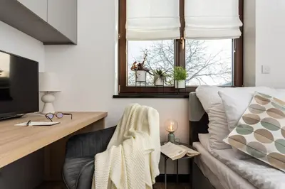 a living room with a couch and a tv and a window at Ucieknij do luksusu: Villa Wola in Kraków