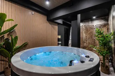 a jacuzzi tub in a room with plants at Ucieknij do luksusu: Villa Wola in Kraków