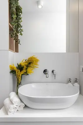 a white bathroom with a tub and a vase of flowers at Ucieknij do luksusu: Villa Wola in Kraków