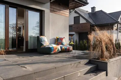 a couch sitting on a patio in front of a house at Ucieknij do luksusu: Villa Wola in Kraków