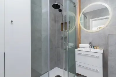 a bathroom with a shower with a sink and a mirror at Lux Apartment Grzegórzecka Estate Cracow by Renters Prestige in Kraków
