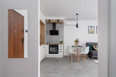 a kitchen and living room with a table and chairs at Lux Apartment Grzegórzecka Estate Cracow by Renters Prestige in Kraków