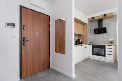 a kitchen with a wooden door in a room at Lux Apartment Grzegórzecka Estate Cracow by Renters Prestige in Kraków