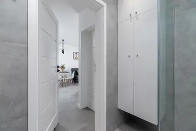a hallway with white cabinets and a dining room at Lux Apartment Grzegórzecka Estate Cracow by Renters Prestige in Kraków