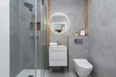 a bathroom with a shower and a toilet and a mirror at Lux Apartment Grzegórzecka Estate Cracow by Renters Prestige in Kraków