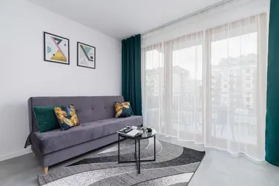 a living room with a couch and a large window at Lux Apartment Grzegórzecka Estate Cracow by Renters Prestige in Kraków
