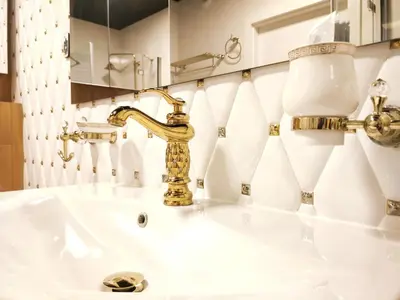 a bathroom with a sink with a gold faucet at Zabłocie 35 by Homeprime in Kraków