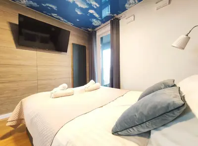 a bedroom with a bed with a tv on the wall at Zabłocie 35 by Homeprime in Kraków