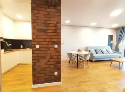 a living room with a brick wall and a table at Zabłocie 35 by Homeprime in Kraków