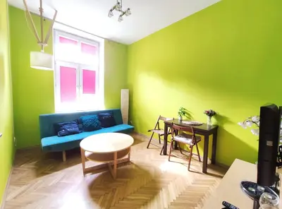 a living room with green walls and a blue couch at Józefa 2 by Homeprime in Kraków
