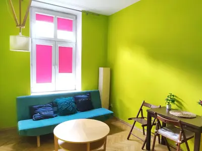 a green room with a blue couch and a window at Józefa 2 by Homeprime in Kraków